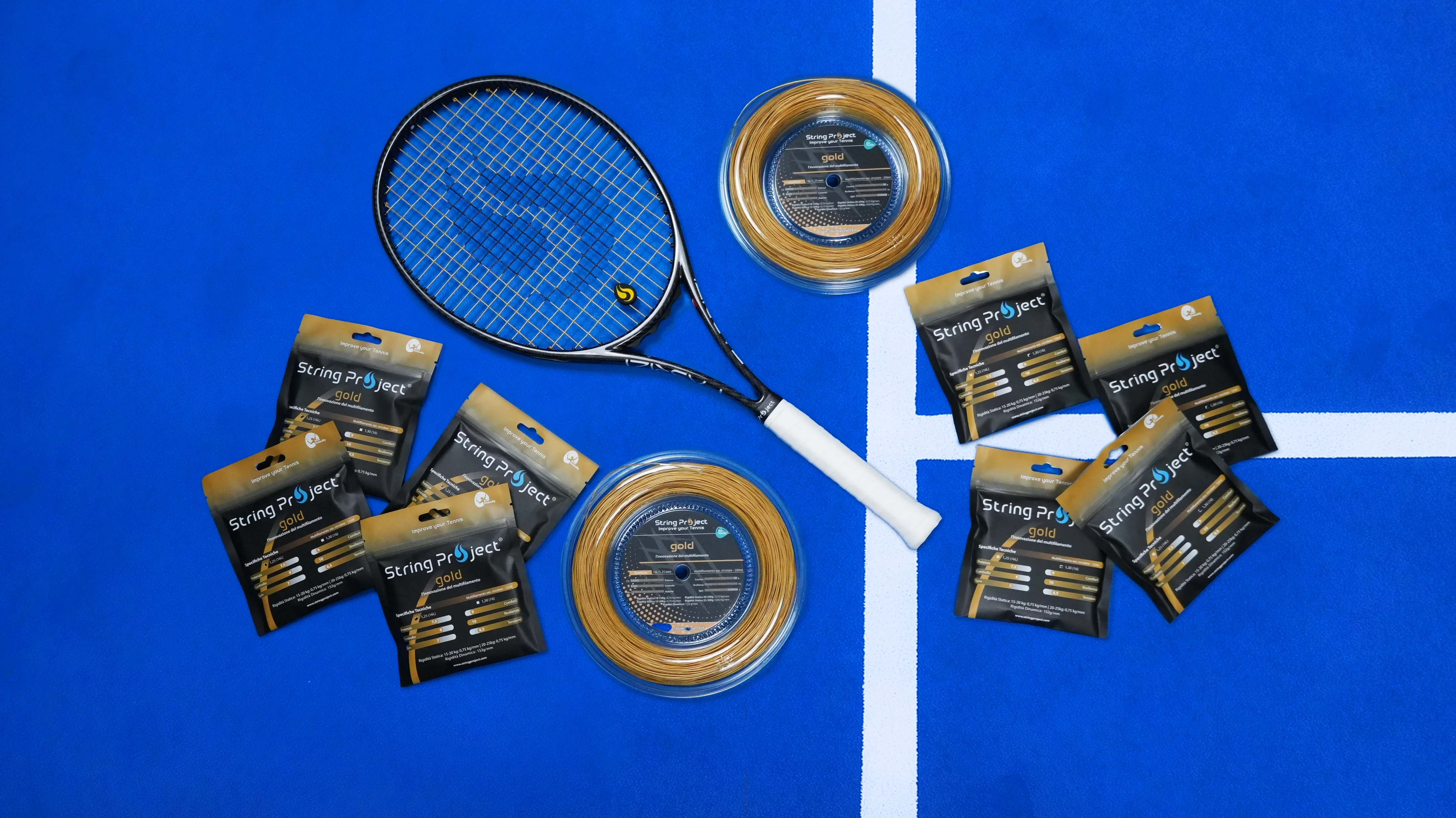 String Project Gold – cuerda de tenis multifilamento oro con raqueta encordada en pista azul